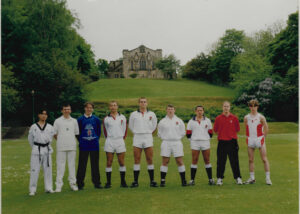 Schoolboys in international kit in front of Durham School Chapel